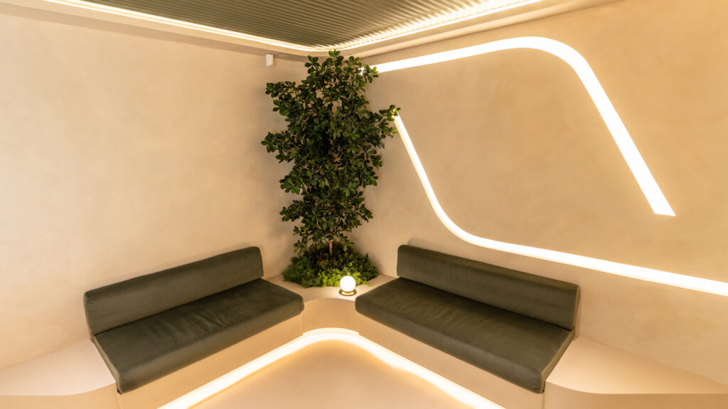 Green lounge seating and indoor tree at AuraWell Health Centre