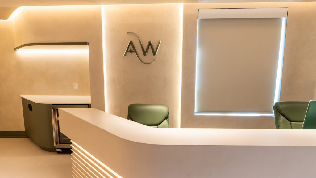 AuraWell reception desk with clinic wall emblem